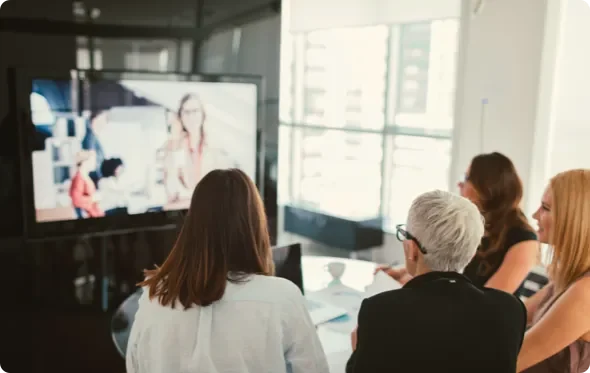 Business people watching a TV screen in a boardroom