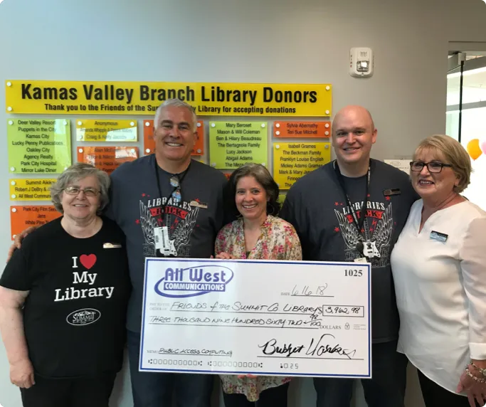 Volunteers holding a big check from All West