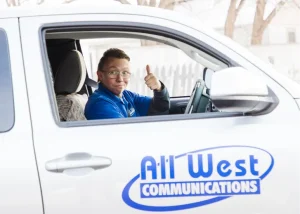 An All West worker in their truck giving the thumbs-up sign