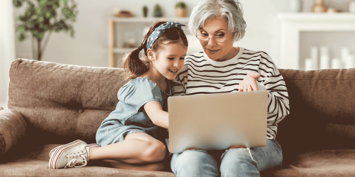woman and granddaughter using laptop