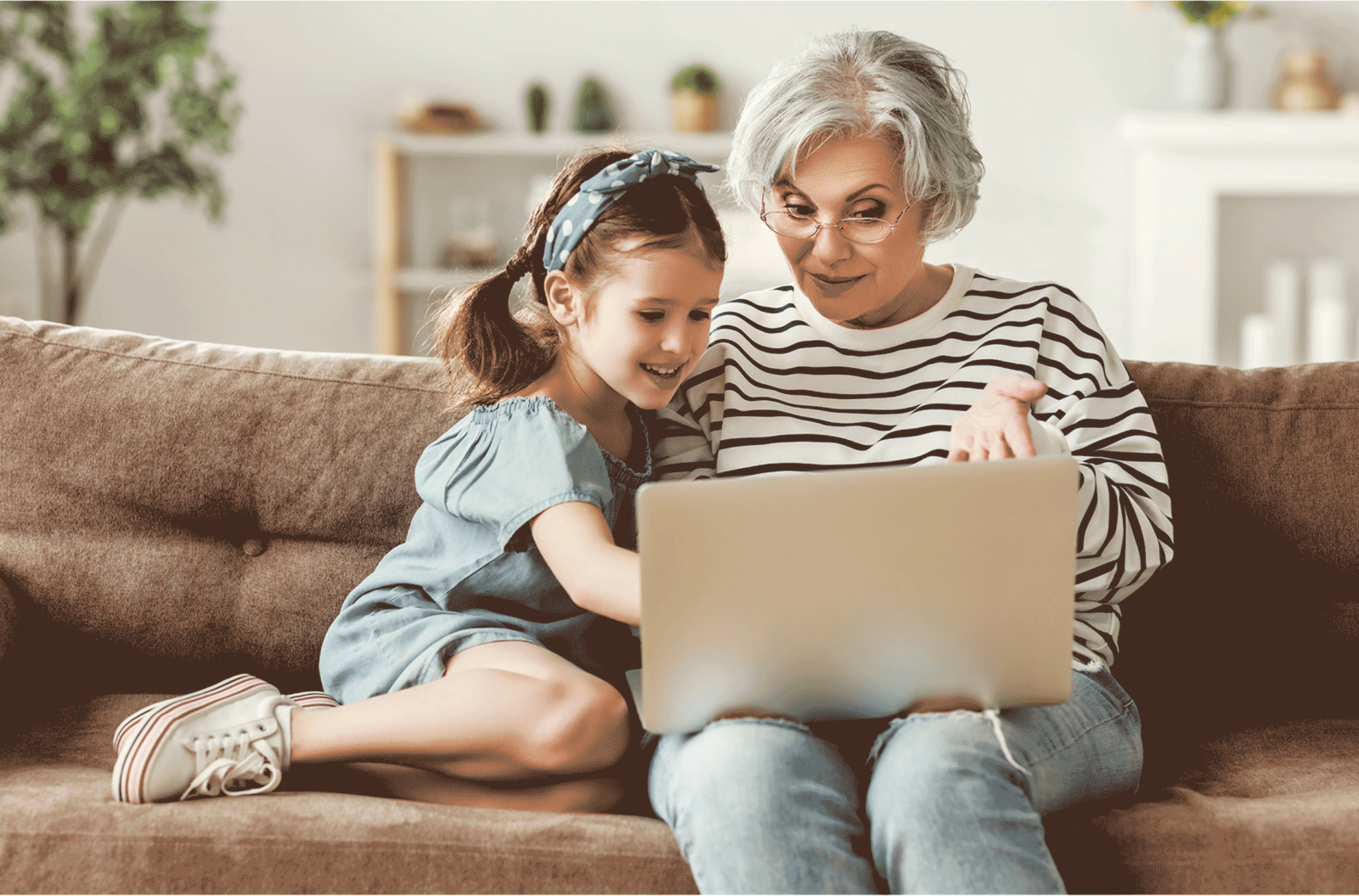 woman and granddaughter using laptop