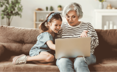 woman and granddaughter using laptop