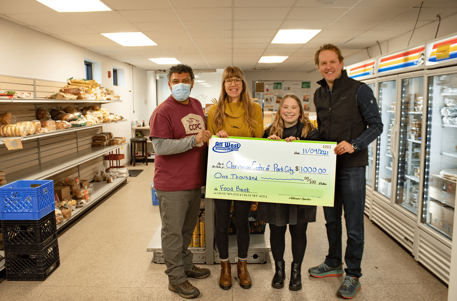 Four people holding a big check from All West to the Christian Center of Park City