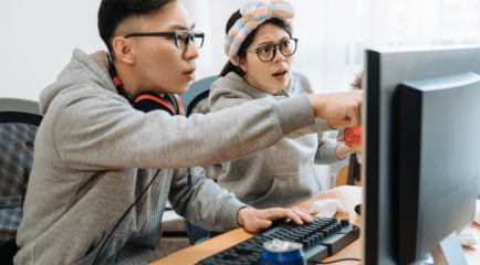 couple looking at computer monitor confused