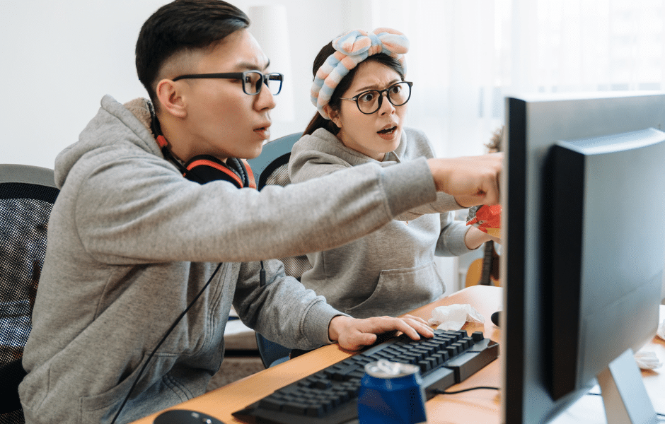 couple looking at computer monitor confused