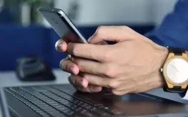 close up of man texting on phone utilizing healthy internet habits and high speed internet upload speed.