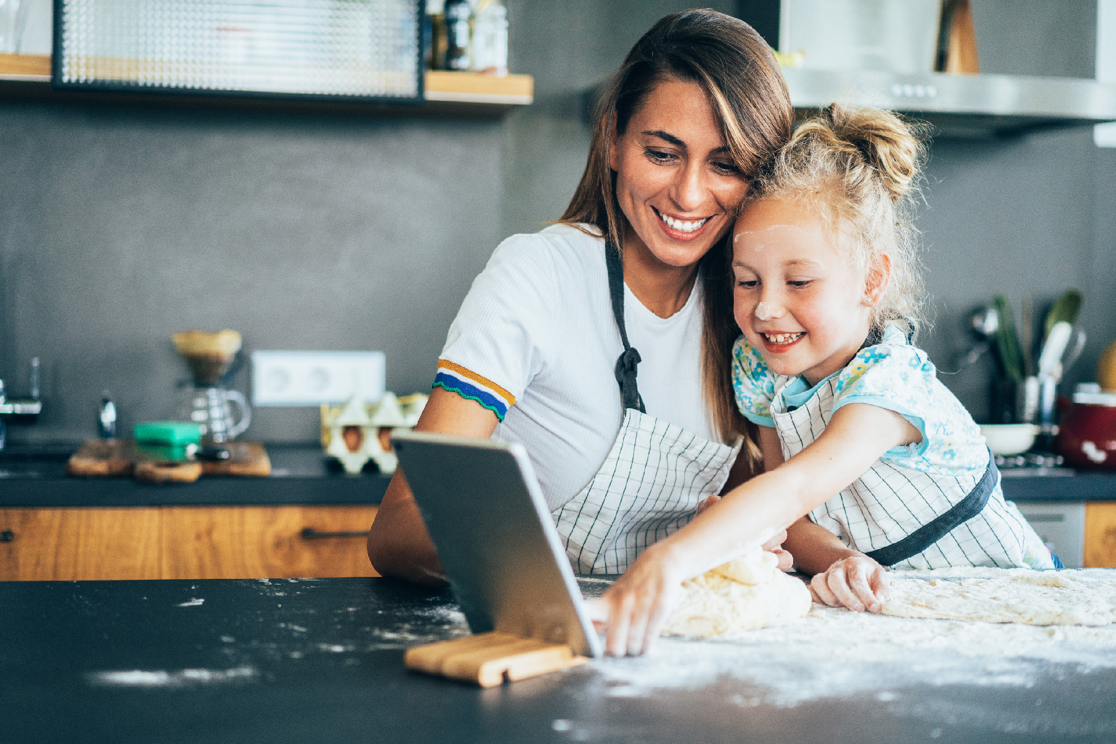 mother and daughter looking at an online recipe while cooking