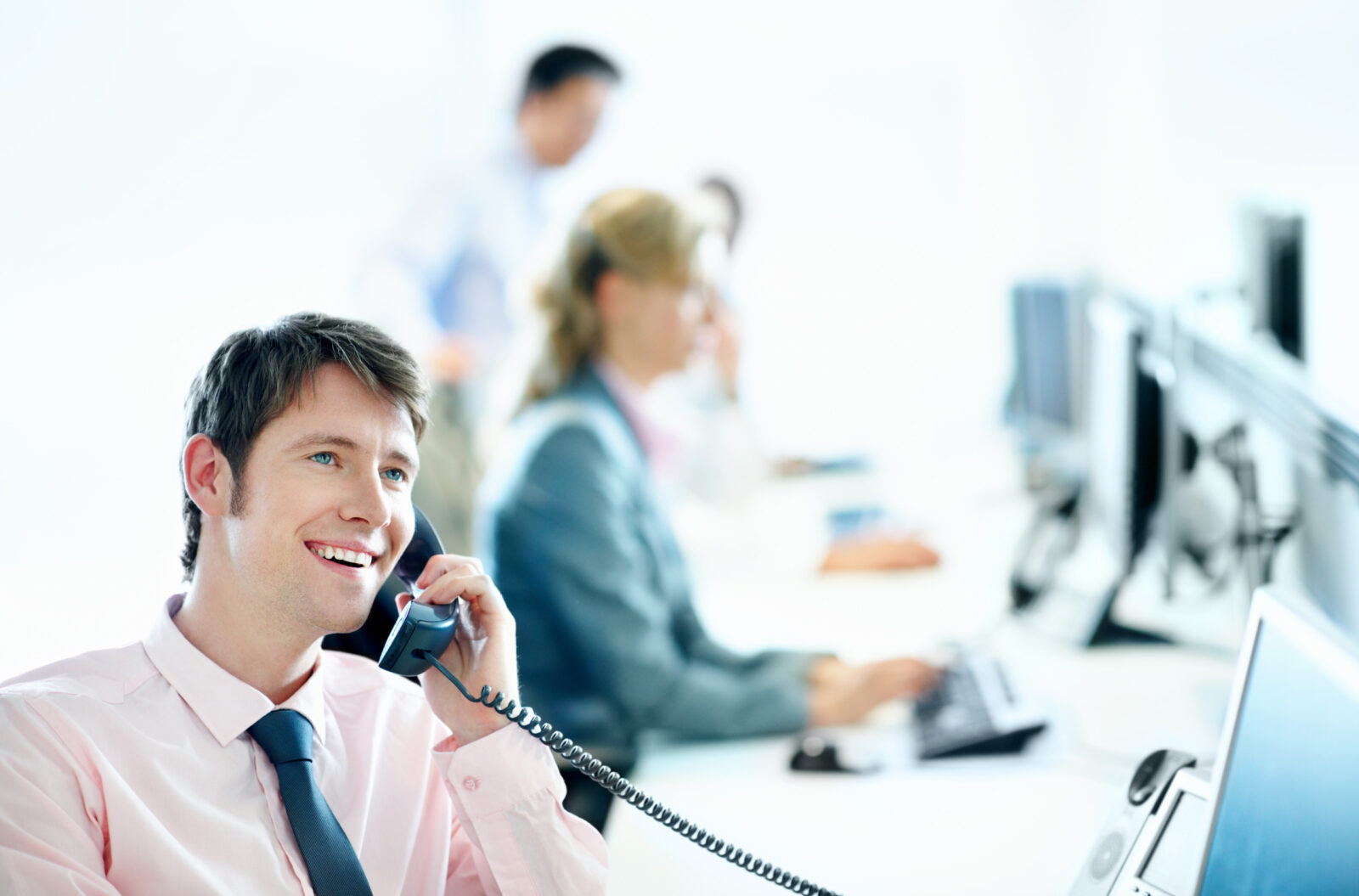 a man in an office, talking on the phone