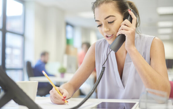 a woman in an office, talking on the phone