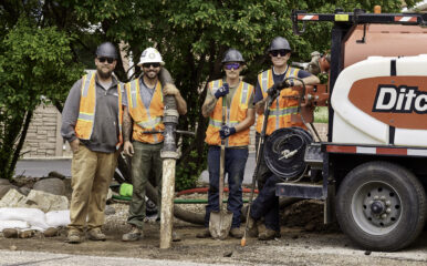 four construction workers posing with equipment