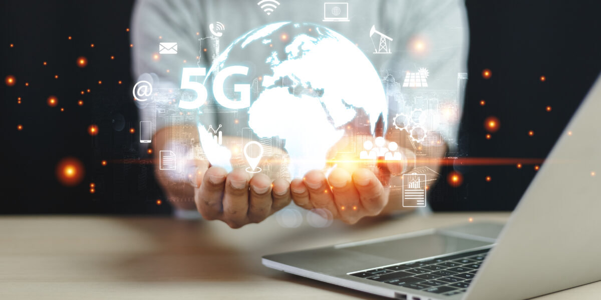 A person holding a glowing holographic globe with '5G' and various digital icons, symbolizing global connectivity and advanced communication technologies. A laptop is partially visible in the foreground. Who is my service provider?