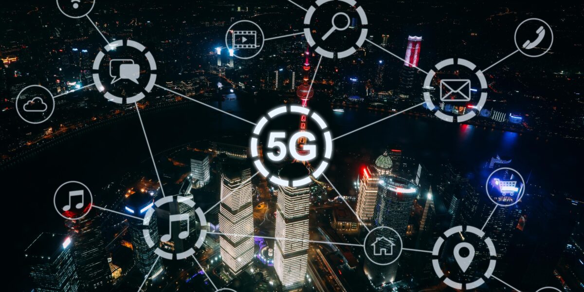 A night aerial view of a city with illuminated buildings and digital icons connected by lines, centered around the '5G' symbol. This image illustrates the wide-reaching capabilities of 5G technology for home internet and various connected services. What is 5g home internet?