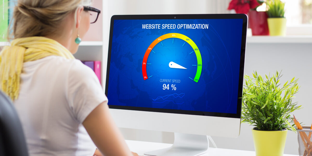 A woman sits at a desk, analyzing a computer screen displaying "Website Speed Optimization" with a performance gauge showing 94%. This image is perfect for illustrating the impact of improved upload and download speed for web services.