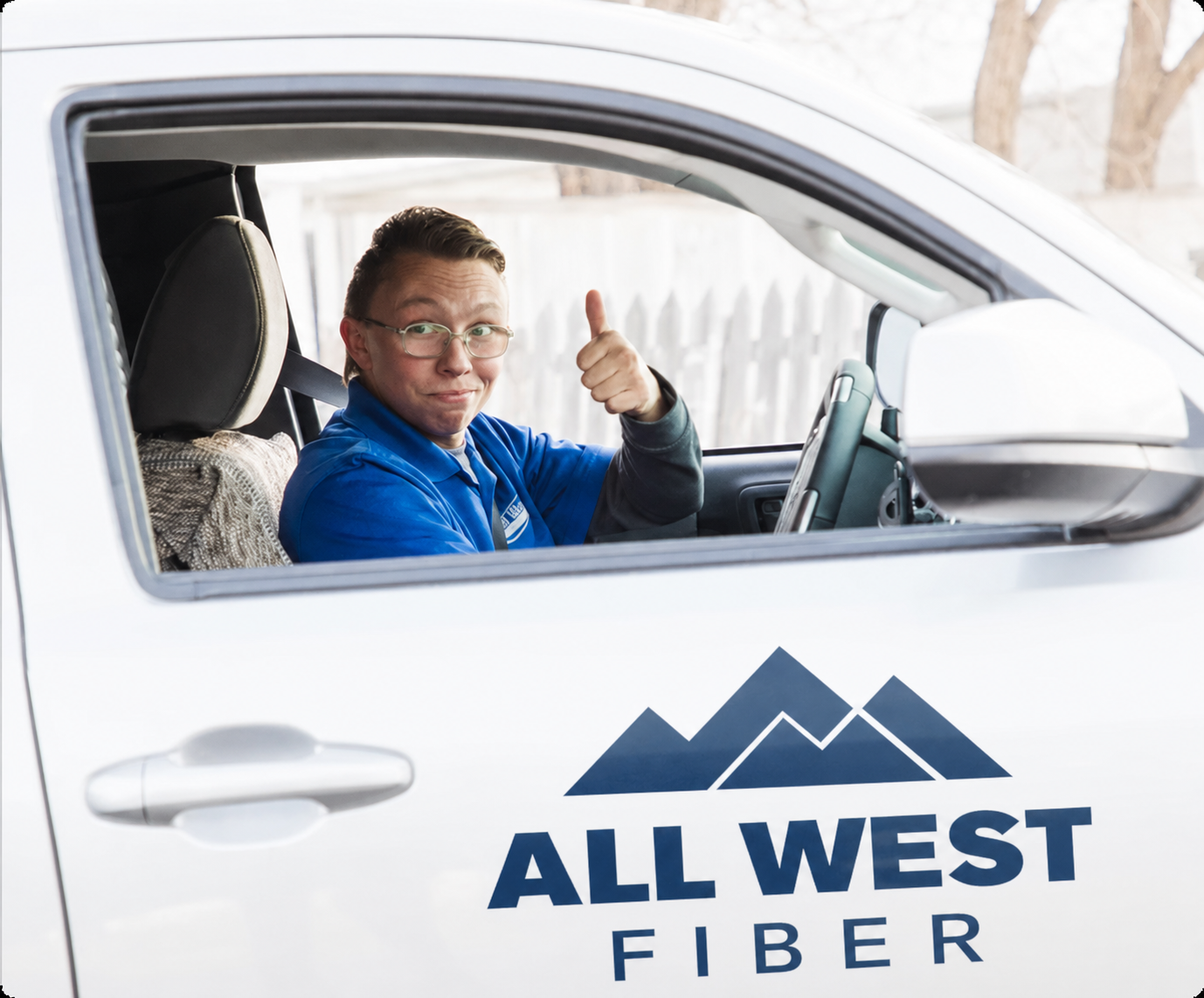 Cheerful All West worker in a company vehicle
