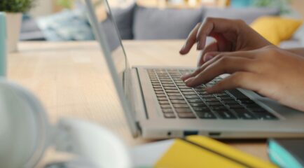 Person using a laptop at home with high-speed fiber internet