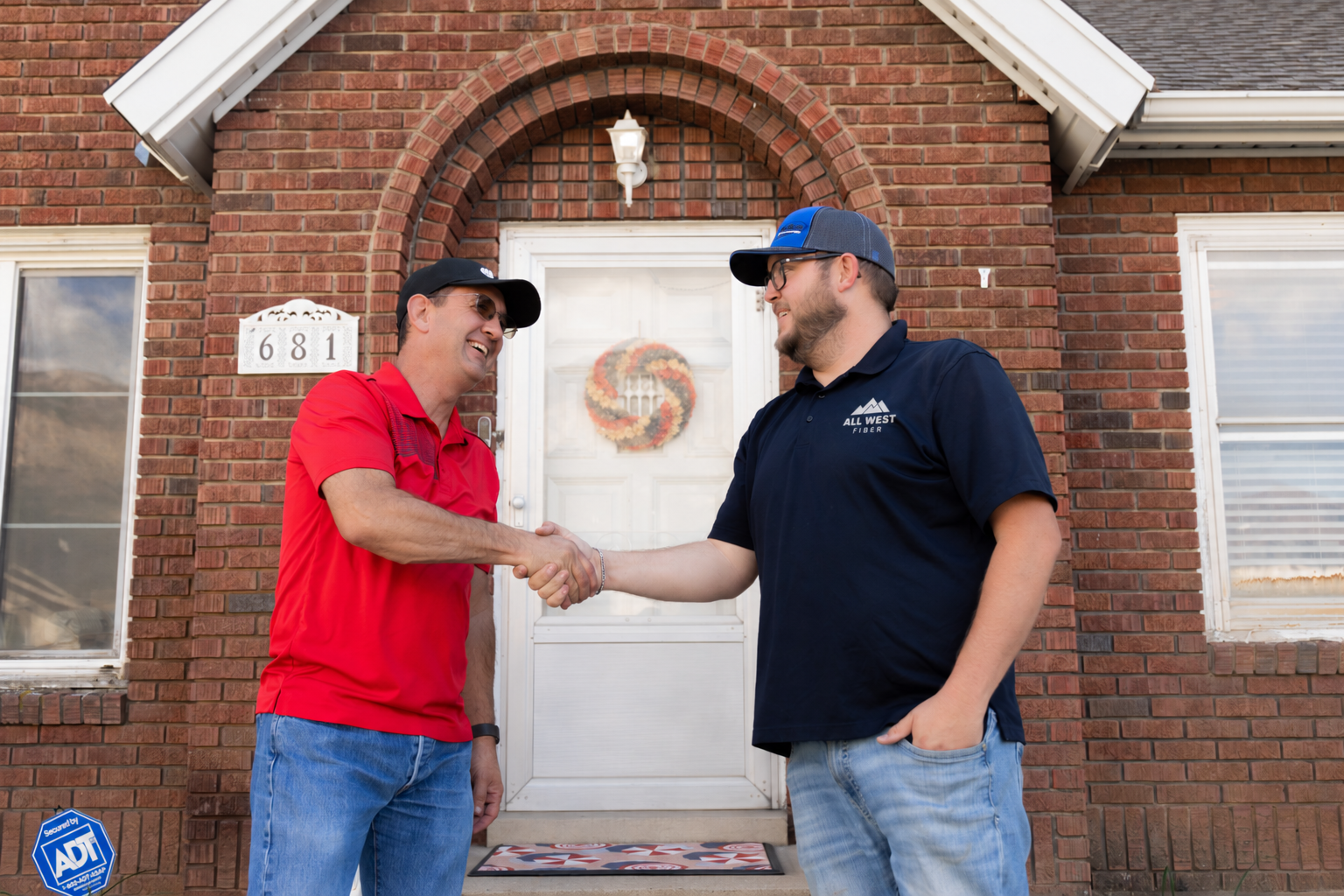 All West Fiber | Friendly Handshake at a Brick Home