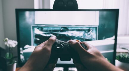 Gamer using a controller while playing a video game at home.